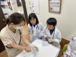 子供達と愛玩動物看護師が検査について勉強している様子
