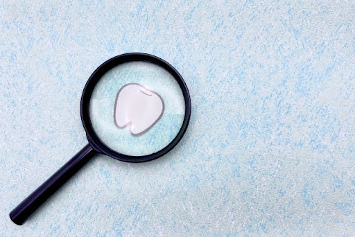 歯に虫眼鏡を当てている様子